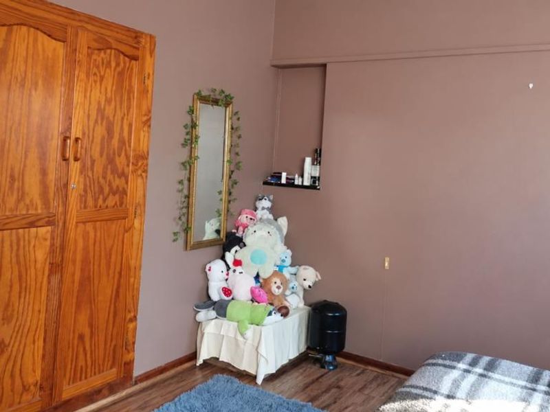 A bedroom featuring laminate flooring and a large built-in wooden wardrobe with a recessed wall shelf.
