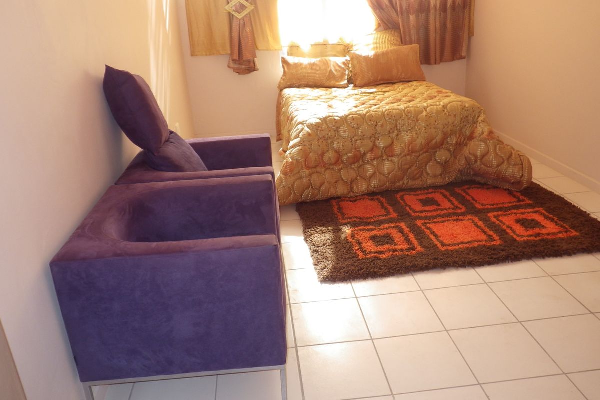 A bedroom featuring tiled flooring and natural light from a window.