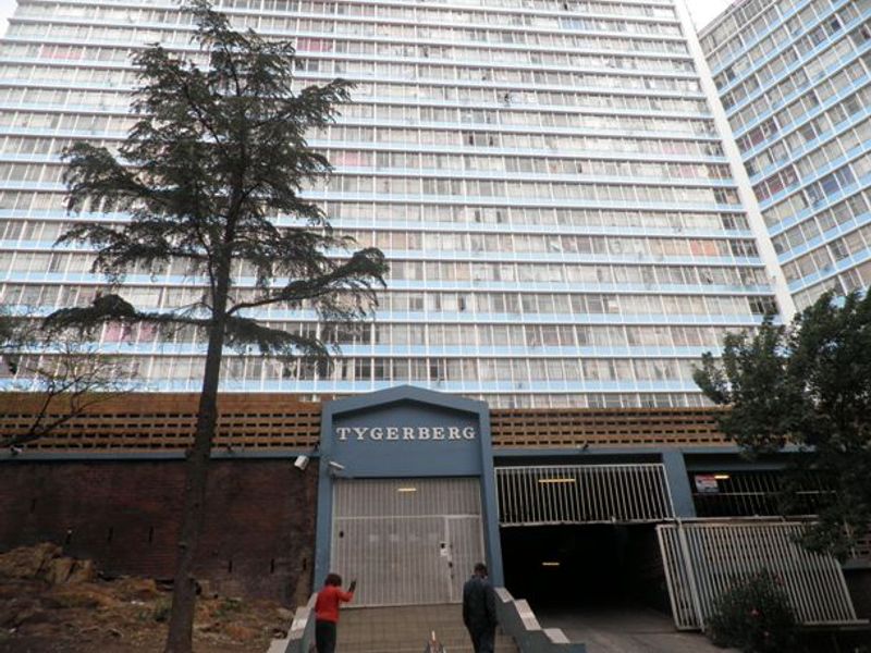 Front exterior view of the Tygerberg apartment building, featuring a secure entrance gate and underground parking access.