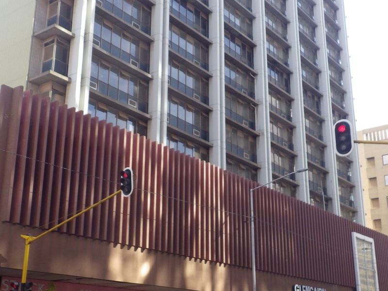 Street-level view of the Glencairn building, featuring a multi-story residential tower above a commercial ground floor with street-facing retail units.