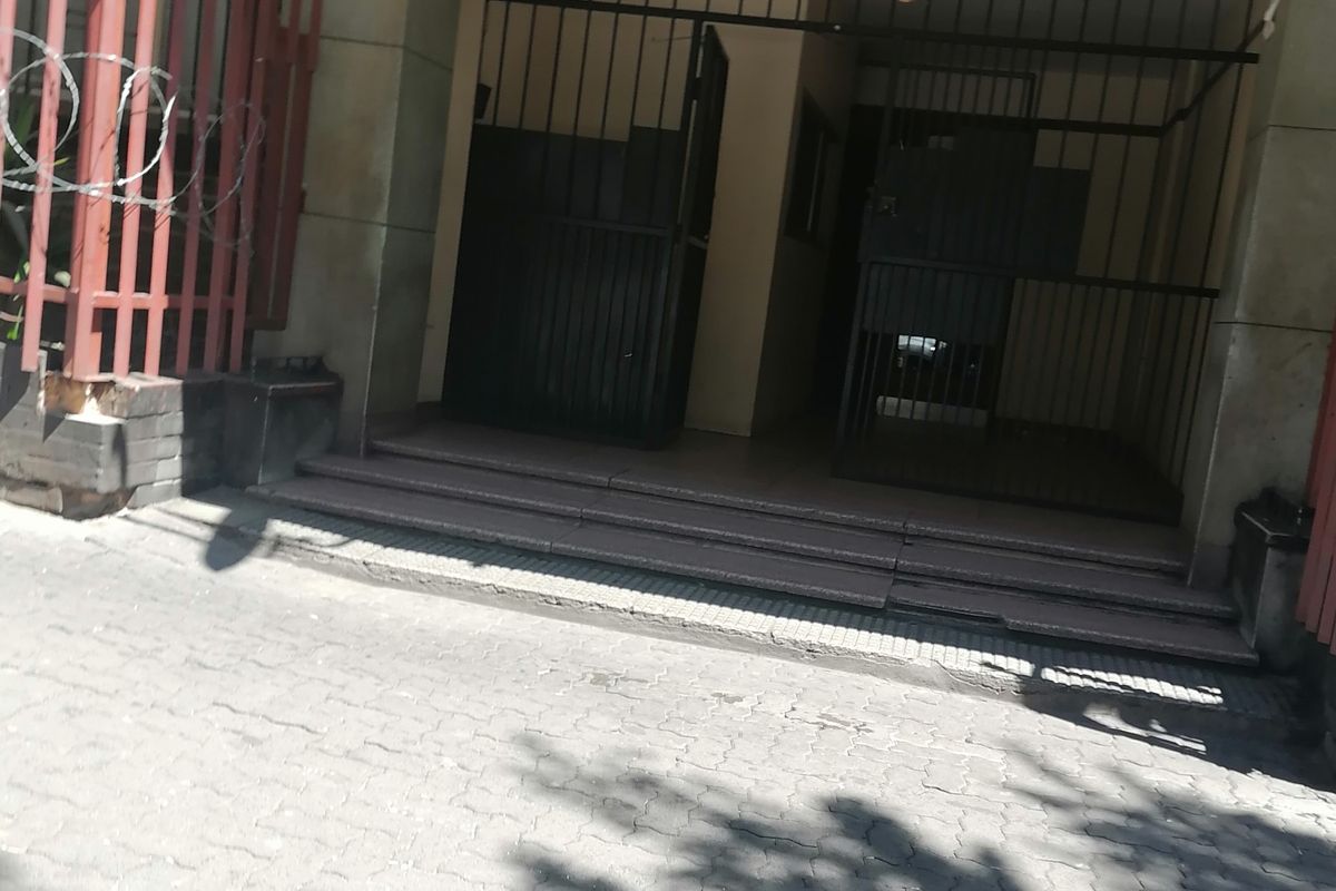 Front entrance of Hyde Park Corner apartment complex featuring a secure gated access point and paved driveway area.
