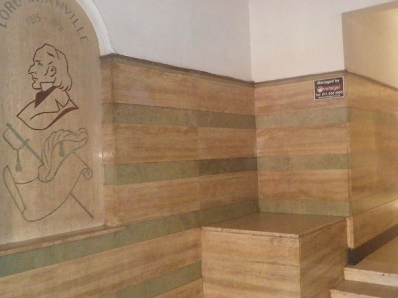 Entrance foyer featuring decorative stone wall cladding and a stone staircase in a well-maintained building.