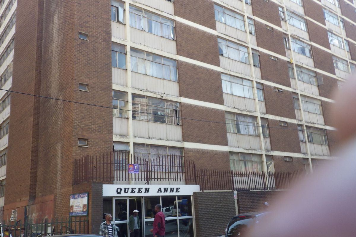 Exterior view of the Queen Anne apartment building, featuring a multi-story brick facade with aluminium windows and a ground-level entrance.