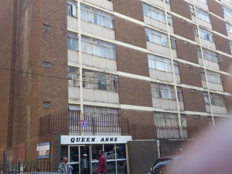 Exterior view of the Queen Anne apartment building, featuring a multi-story brick facade with aluminium windows and a ground-level entrance.