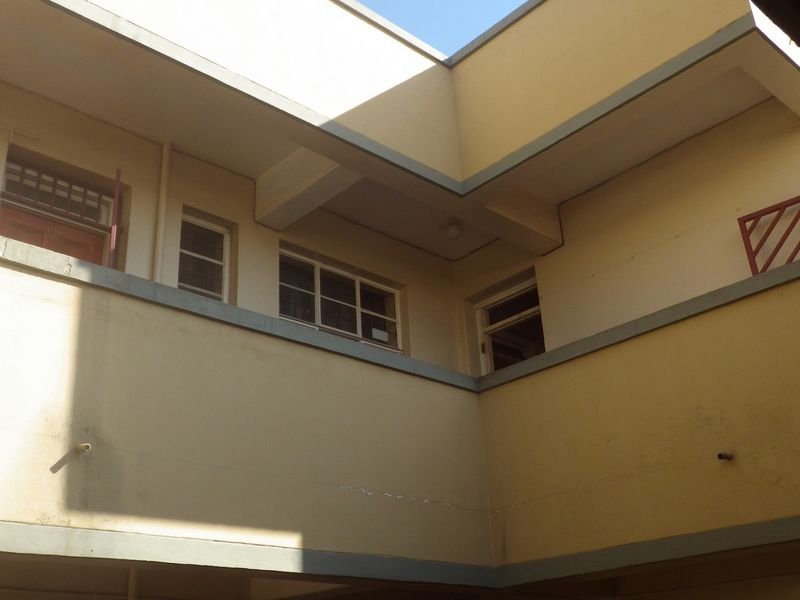 An upward view of the building exterior showing the rear facade, balcony balustrades, and window placements.