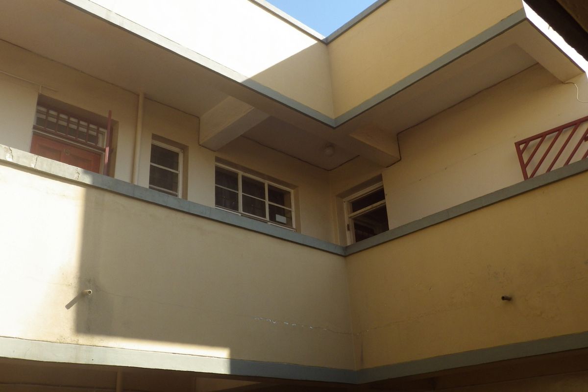 An upward view of the building exterior showing the rear facade, balcony balustrades, and window placements.
