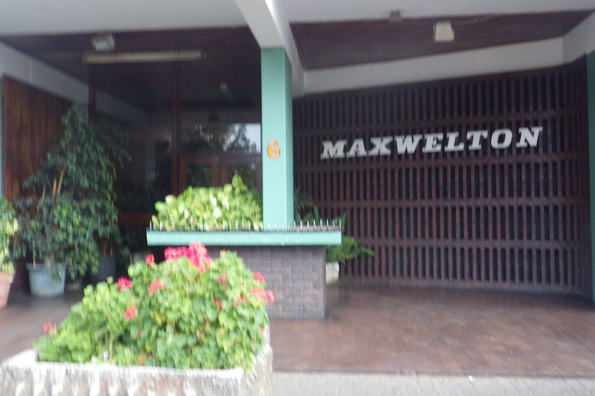 The entrance facade of Maxwelton apartment building, featuring a covered entryway with timber slat detailing and a masonry planter box.