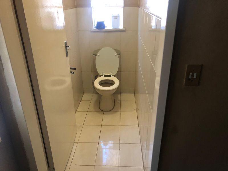A compact, functional bathroom featuring tiled walls and flooring with a standard toilet fixture.