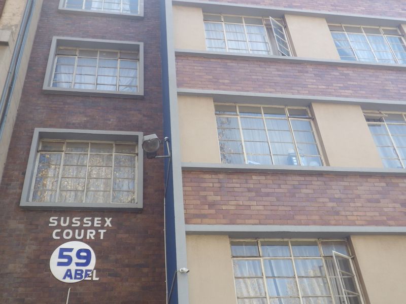 Exterior view of Sussex Court, a multi-story residential building featuring brick facade construction and steel-framed windows.
