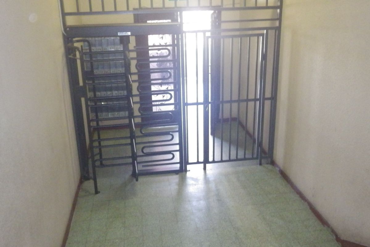 An entrance foyer featuring a security gate and integrated mailboxes, providing a secure access point to the property.