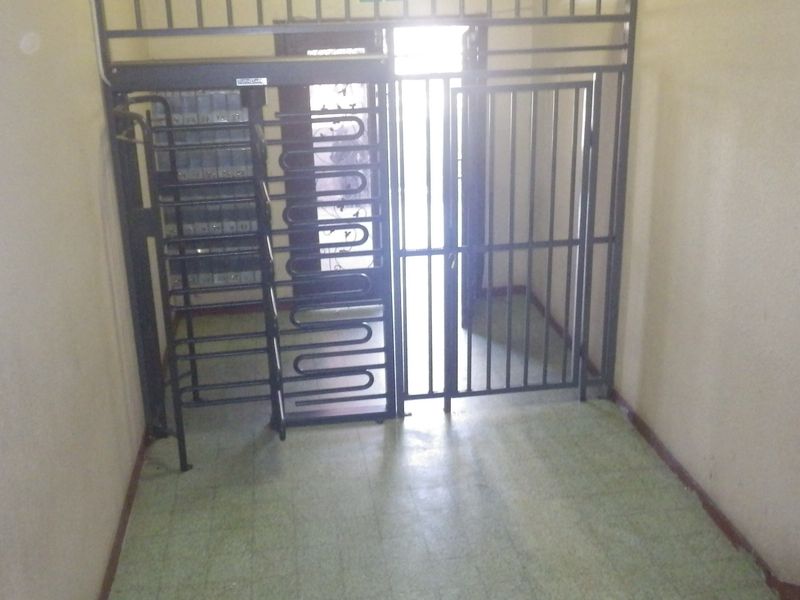 An entrance foyer featuring a security gate and integrated mailboxes, providing a secure access point to the property.